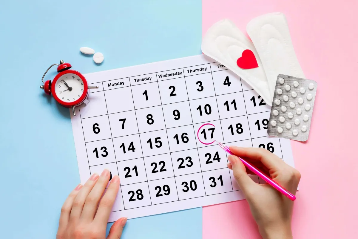 Woman circling the day her menstrual cycle begins