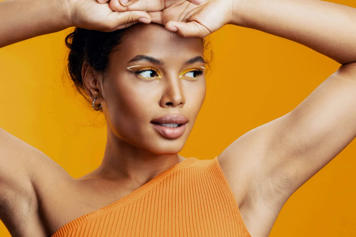 Woman raising her arms showing her armpits after a treatment for dark armpits